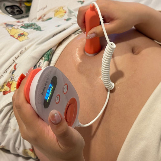 Pregnant mother using BabyNera home fetal doppler on her belly to monitor baby heartbeat during pregnancy at home.
