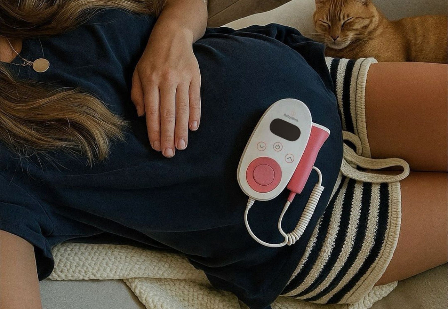 Mum using a fetal doppler on her abdomen in early pregnancy to find baby’s heartbeat